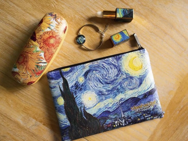 Kosmetyczka Vincent van Gogh Gwiaździsta noc leżąca na stole z innymi akcesoriami
